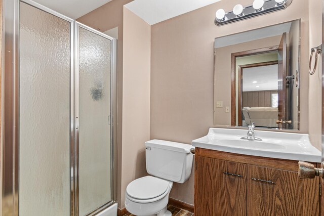 bathroom featuring toilet, a shower stall, vanity, and baseboards