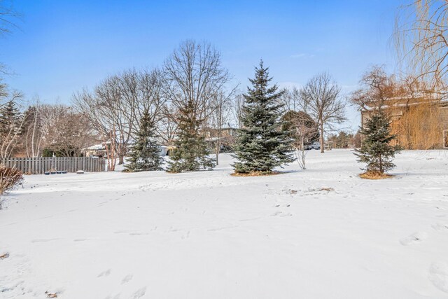 snowy yard featuring fence