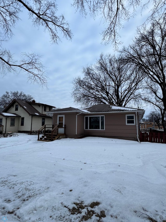 view of snow covered back of property