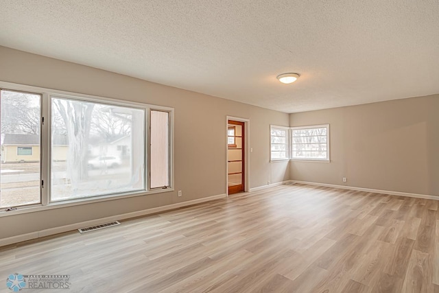 empty room featuring light hardwood / wood-style flooring and a textured ceiling