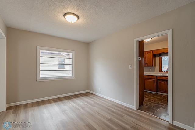 unfurnished room featuring wood-type flooring and a textured ceiling