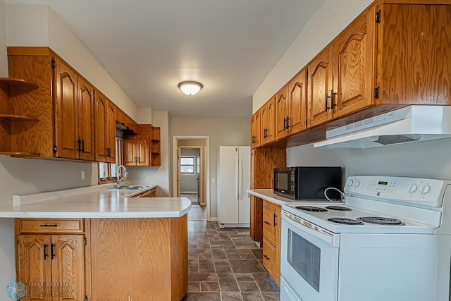 kitchen with white appliances, kitchen peninsula, and sink