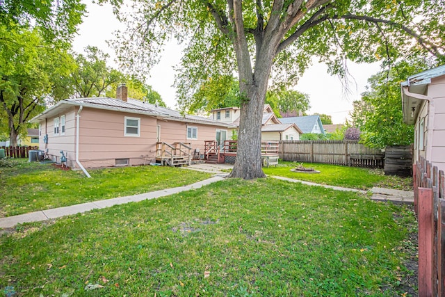 view of yard featuring a wooden deck and central AC