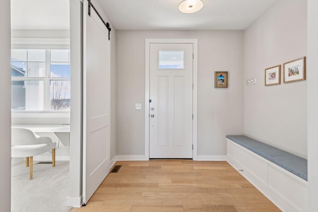 foyer with a barn door and light wood-type flooring