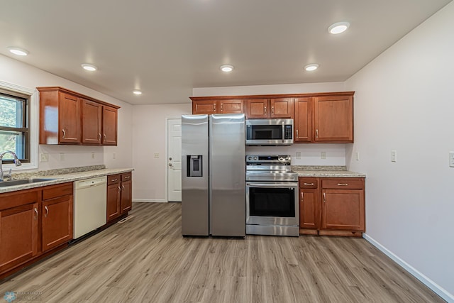 kitchen featuring appliances with stainless steel finishes, sink, and light hardwood / wood-style floors