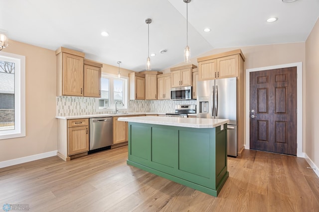 kitchen with stainless steel appliances, a kitchen island, pendant lighting, and light brown cabinets