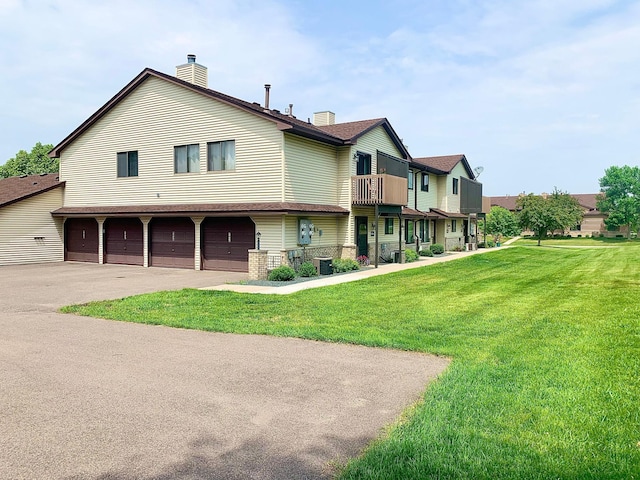 view of front of home featuring a garage, central air condition unit, and a front lawn