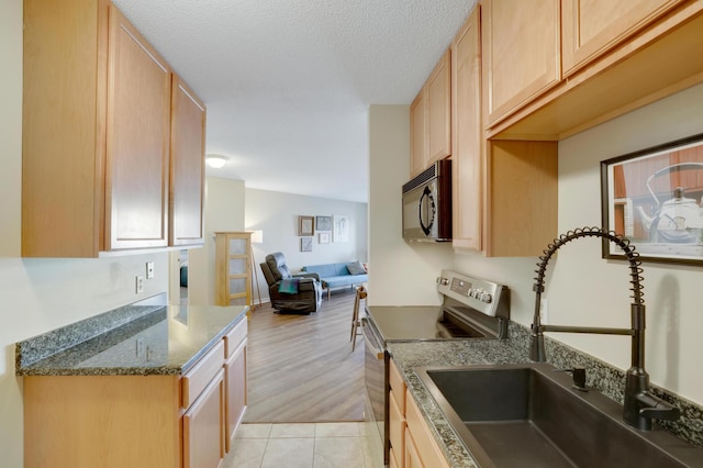 kitchen featuring electric range, open floor plan, a sink, a textured ceiling, and black microwave