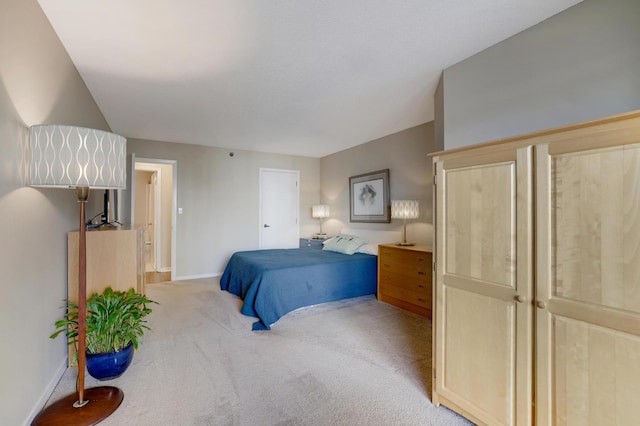 bedroom featuring baseboards and light colored carpet