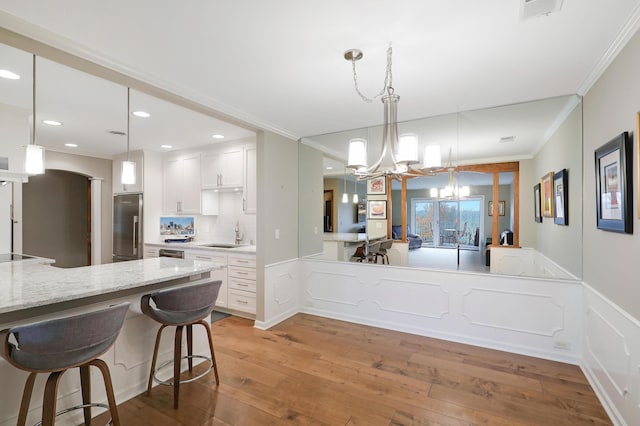 kitchen with high end refrigerator, kitchen peninsula, and white cabinets