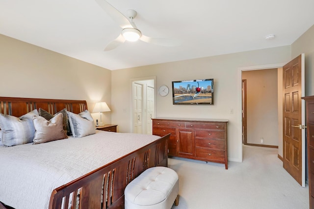 carpeted bedroom with ceiling fan and ensuite bath