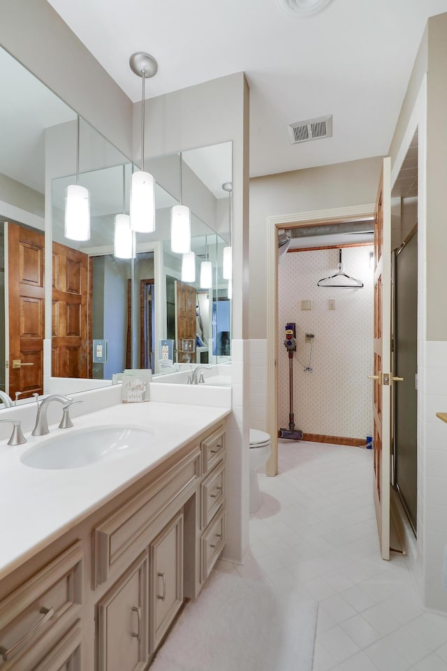 bathroom featuring vanity, toilet, and an enclosed shower