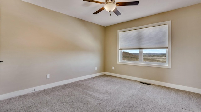 carpeted spare room featuring ceiling fan