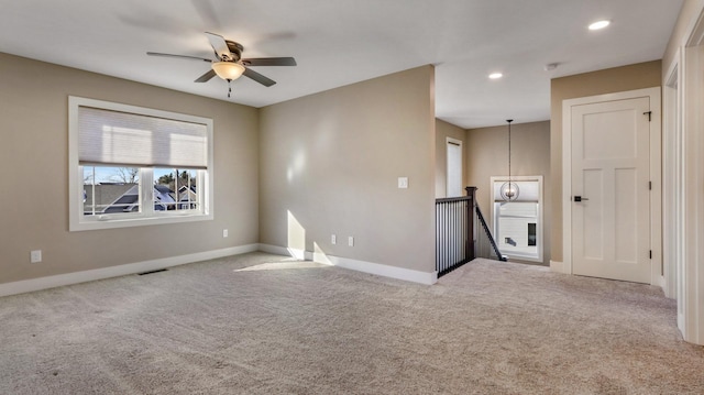 carpeted spare room featuring ceiling fan