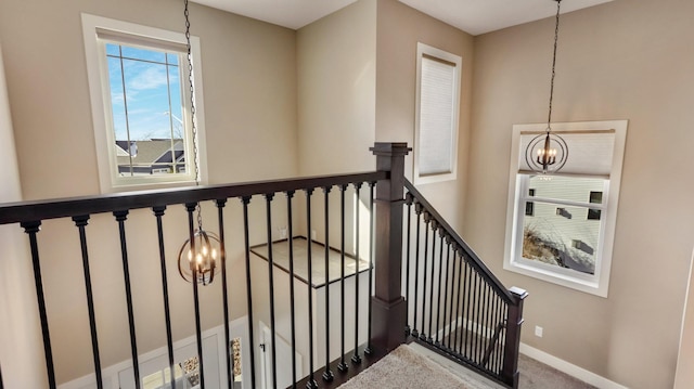 stairway featuring an inviting chandelier and carpet floors