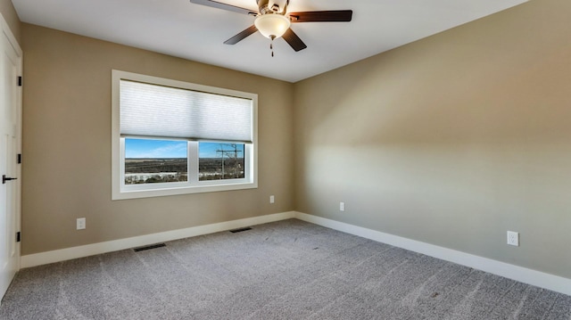 carpeted spare room featuring ceiling fan