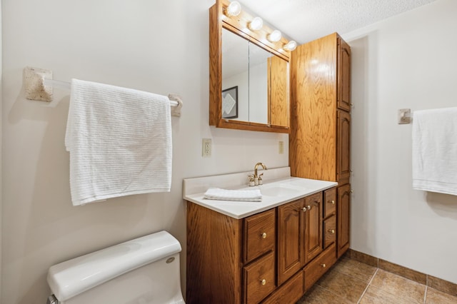 bathroom with vanity, a textured ceiling, and toilet