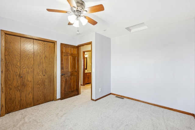 unfurnished bedroom with light colored carpet, ceiling fan, and a closet