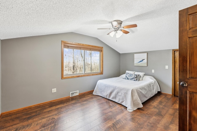 bedroom with ceiling fan, lofted ceiling, dark hardwood / wood-style floors, and a textured ceiling