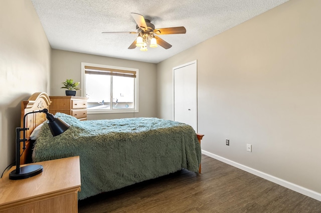 bedroom featuring dark wood finished floors, ceiling fan, baseboards, and a textured ceiling