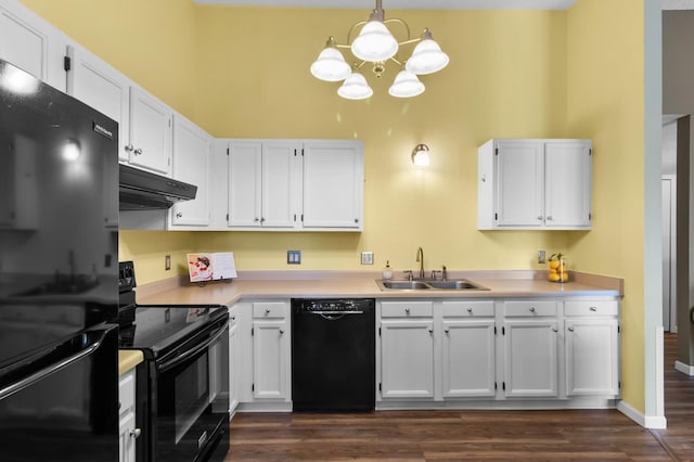 kitchen featuring under cabinet range hood, white cabinetry, black appliances, and a sink