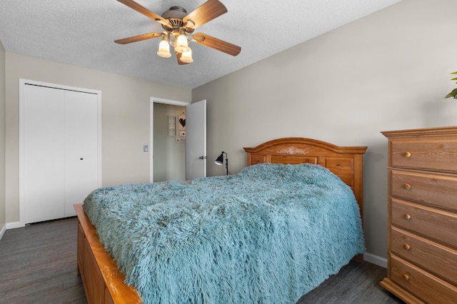 bedroom with a textured ceiling, a closet, baseboards, ceiling fan, and dark wood-style flooring