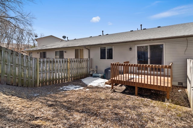 rear view of property with a deck, fence, roof with shingles, and crawl space