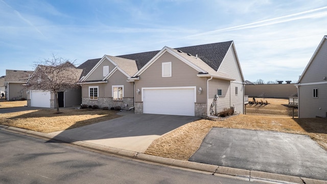 view of front facade featuring stone siding, concrete driveway, a garage, and a shingled roof