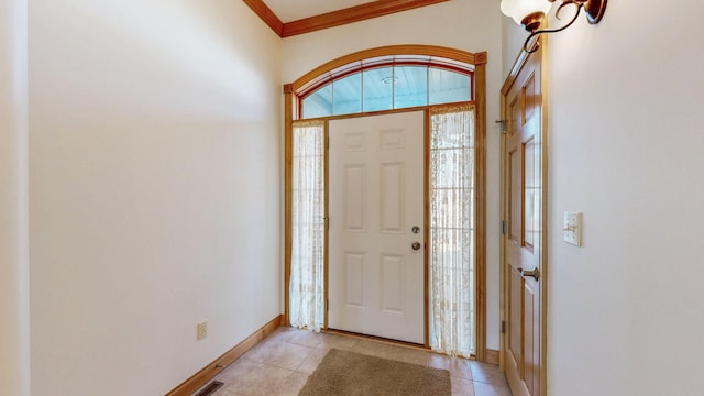 entryway with light tile patterned flooring, crown molding, and baseboards