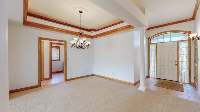 carpeted foyer featuring ornate columns, baseboards, crown molding, and a tray ceiling