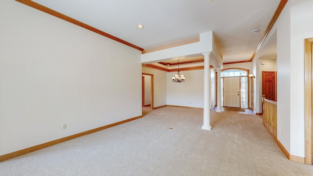 interior space with light carpet, a raised ceiling, ornamental molding, decorative columns, and baseboards