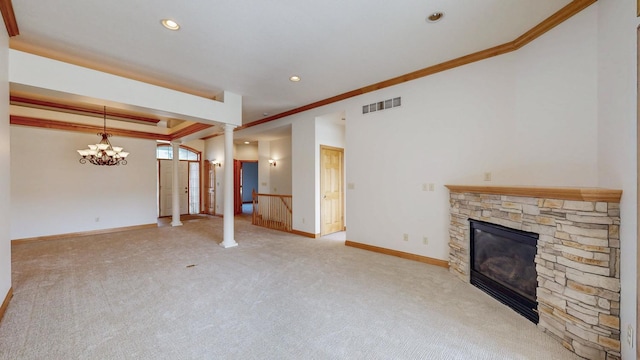 unfurnished living room with visible vents, ornamental molding, a fireplace, baseboards, and ornate columns