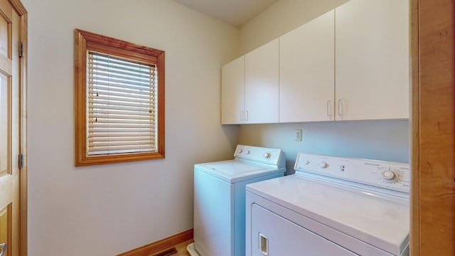 laundry area featuring washer and clothes dryer, cabinet space, and baseboards