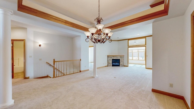 unfurnished living room featuring an inviting chandelier, a raised ceiling, baseboards, and light colored carpet