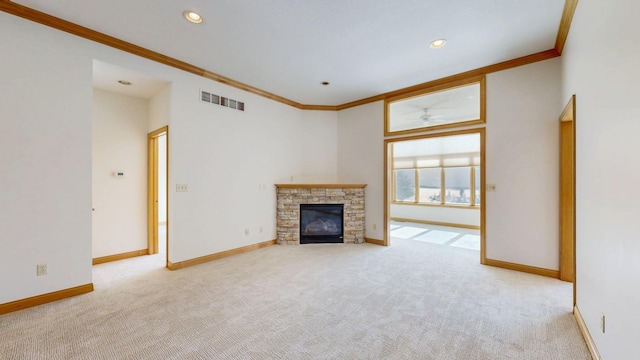 unfurnished living room featuring crown molding, visible vents, a fireplace, baseboards, and carpet flooring