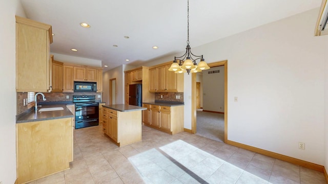 kitchen featuring dark countertops, an inviting chandelier, a sink, backsplash, and black appliances