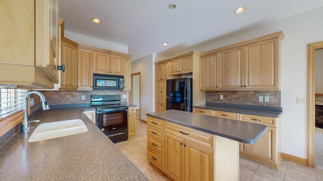 kitchen featuring backsplash, light brown cabinetry, dark countertops, a sink, and black appliances