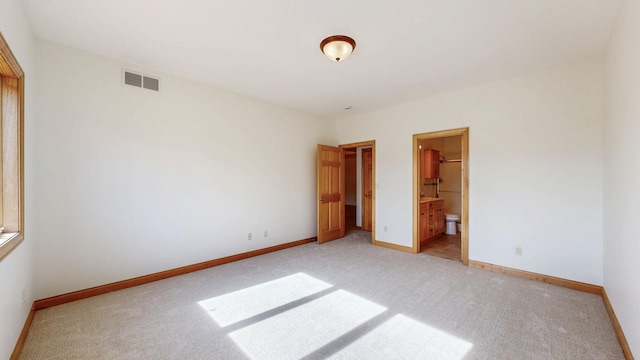 unfurnished bedroom featuring light colored carpet, baseboards, and visible vents