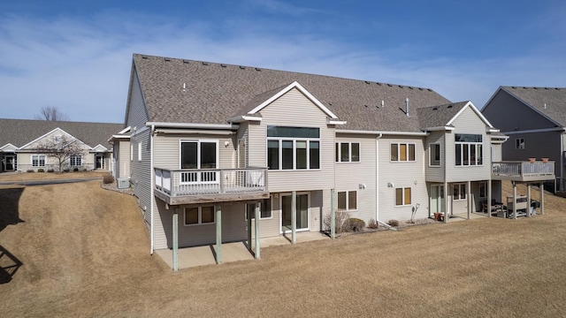 back of property featuring a deck and roof with shingles