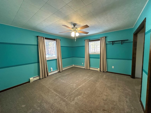 spare room featuring ceiling fan, carpet, and a baseboard heating unit