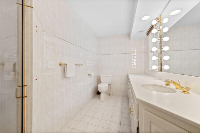 bathroom featuring tile patterned floors, toilet, tile walls, and vanity