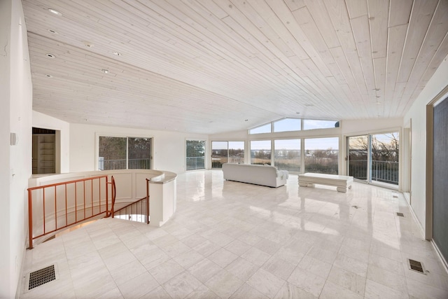 unfurnished sunroom featuring lofted ceiling, plenty of natural light, and visible vents