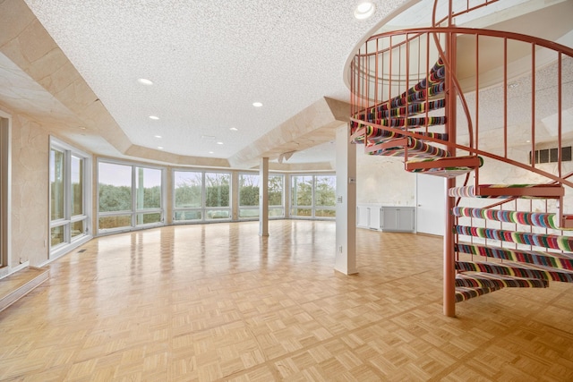 unfurnished living room with a textured ceiling, stairway, visible vents, and recessed lighting