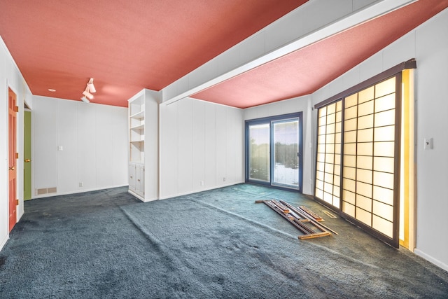 unfurnished room with visible vents and dark colored carpet