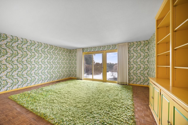 unfurnished room with baseboards and wallpapered walls