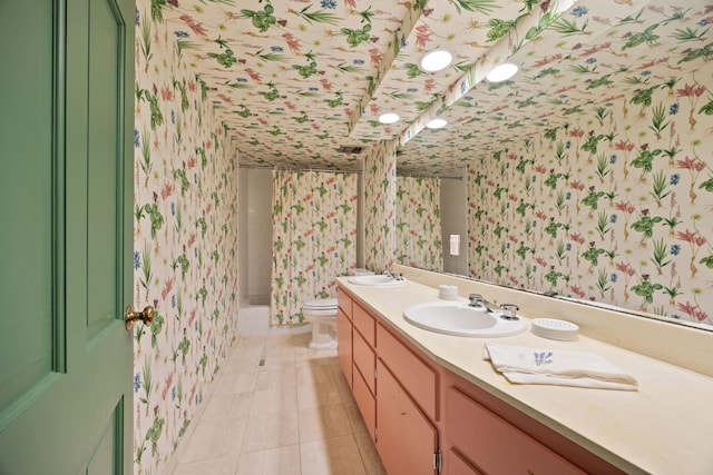 bathroom featuring toilet, wallpapered walls, a sink, and tile patterned floors