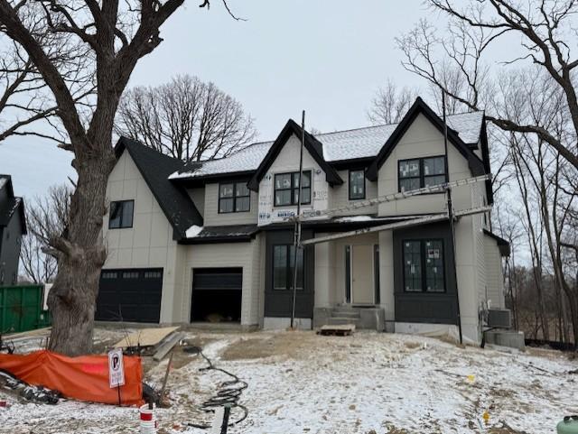 view of front of property featuring a garage and central AC unit