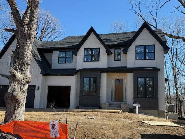 modern farmhouse style home with an attached garage and entry steps