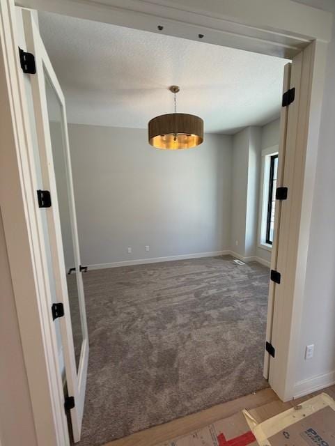 carpeted spare room featuring baseboards