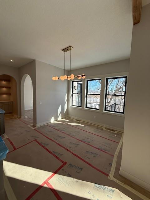 interior space featuring arched walkways and baseboards